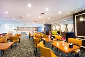 Hotel Montoview Yonezawa في يونيزاوا: غرفة طعام مع طاولات وكراسي خشبية