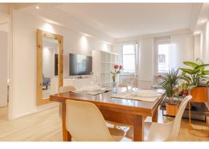 comedor con mesa de madera y sillas blancas en Residenza Cristoforo, en Udine