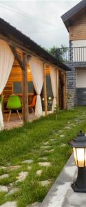ein Haus mit einer Terrasse mit einem grünen Stuhl in der Unterkunft NOY Guest House B&B in Wanadsor