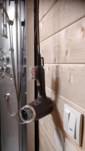 głowicę prysznicową wiszącą na ścianie obok toalety w obiekcie Uneallika hubane saunaga majake "Hoburaud" w mieście Pae
