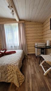 a bedroom with a bed and a desk and a table at Guest House Firebird in Belokurikha