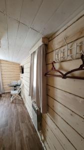 a room with a wooden wall with a bed and a window at Guest House Firebird in Belokurikha