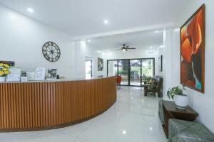 a lobby with a reception desk and a clock on the wall at The Suites @ Bellavista in Isabel