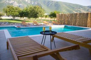 a pool with a table and two glasses of champagne at Villa Village Mostar in Mostar