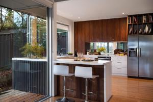 a kitchen with a island with bar stools at Bilsons Landing East in Daylesford