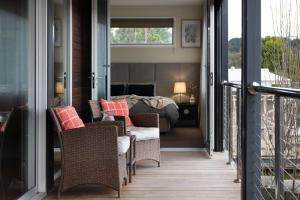 un porche con sillas y una cama en un dormitorio en Bilsons Landing East en Daylesford