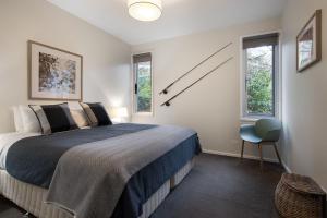 1 dormitorio con 1 cama y reloj en la pared en Bilsons Landing East en Daylesford