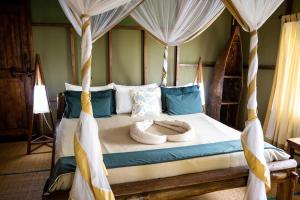 1 dormitorio con 1 cama con dosel en Simply Saadani Camp, A Tent with a View Safaris en Mkwaja