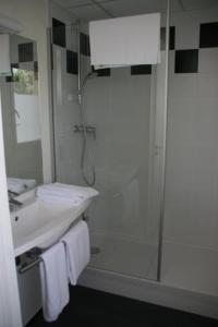 een witte badkamer met een douche en een wastafel bij ibis Styles Bourbon Lancy in Bourbon-Lancy