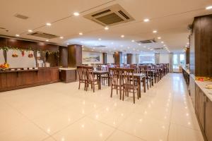 a restaurant with tables and chairs and a bar at Navy Hotel Nha Trang in Nha Trang