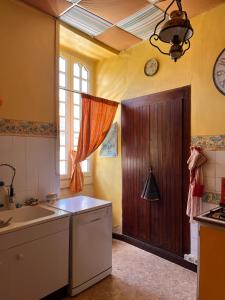- une cuisine avec un évier et une porte en bois dans l'établissement Laroumette, à Salies-de-Béarn