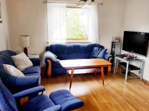 a living room with blue couches and a table at Four-Bedroom Holiday home in Bygstad 1 in Bygstad