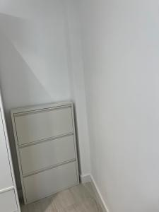 um quarto com uma parede branca e uma gaveta em Apartamento Arena Benidorm em Benidorm