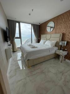 a bedroom with a large bed and a large window at Copacabana jomtien beach 53 Floor in Jomtien Beach