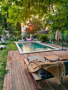 een zwembad in een tuin met een houten terras bij Apartma Medoši in Izola