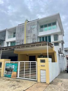 a white and yellow building with a gate at Homestay Raudhah, Taman Gombak Ria in Batu Caves