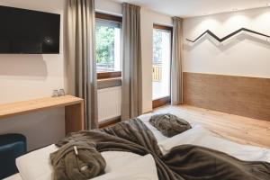 1 dormitorio con 1 cama y TV en la pared en Hotel Lahnerhof en Vipiteno