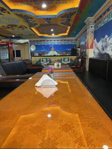 una gran mesa de conferencias en una sala con un mural en The Boudha Inn, en Katmandú