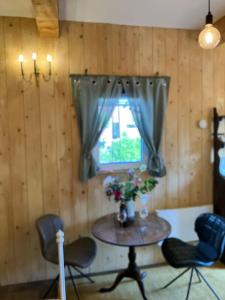 Zimmer mit einem Tisch, Stühlen und einem Fenster in der Unterkunft The Tiny Garage in Kampen
