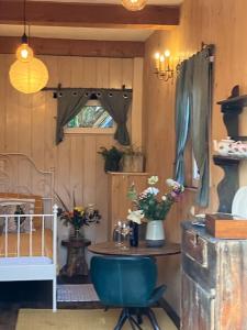 een kamer met een blauwe stoel en een tafel met bloemen bij The Tiny Garage in Kampen