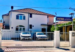 two cars parked in front of a house with a fence at DVOKREVETNA SOBA SA KUPAONICOM in Vodice
