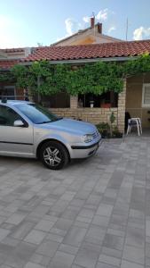 un coche aparcado en un estacionamiento frente a una casa en DVOKREVETNA SOBA SA KUPAONICOM, en Vodice