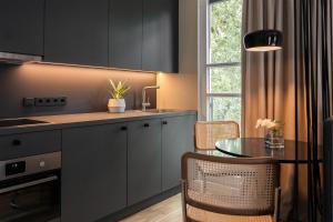 uma cozinha com armários pretos, uma mesa e uma janela em HApato em Munique