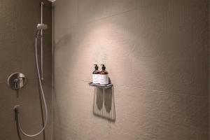 um chuveiro com duas garrafas de vinho numa prateleira na casa de banho em HApato em Munique