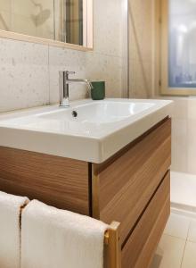 La salle de bains est pourvue d'un lavabo blanc et d'un miroir. dans l'établissement Apartment Via Sant'Alessandro 22 - Sostify, à Bergame