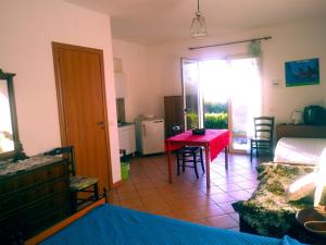 a living room with a red table and a kitchen at CasaEtna Parapiedimonte Et in Fiumefreddo di Sicilia