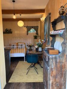 eine Küche mit einem Tisch und einem Bett in einem Zimmer in der Unterkunft The Tiny Garage in Kampen