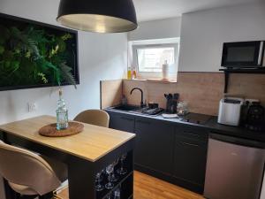 a kitchen with a sink and a table with chairs at Caen, Tu m'aimes - Suite Romantique in Caen