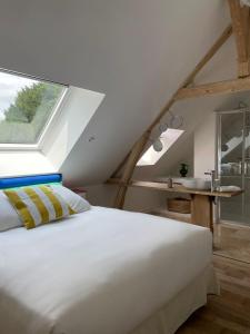 a white bed in a room with a window at MAISON SEIZE in Préaux