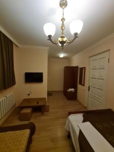 Habitación con lámpara de araña y sala de estar. en Piano Hotel en Tiflis