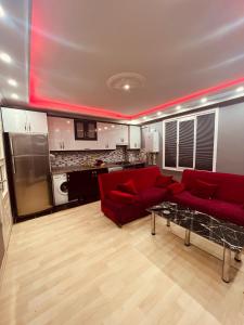 a living room with a red couch and a kitchen at Venüs apart in Istanbul