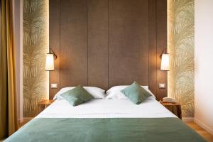 a bedroom with a large bed with two green pillows at Hotel Life in Rimini