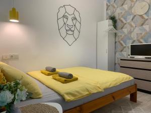 グダニスクにあるApartament UNEZKOのベッドルーム1室(黄色いシーツ付きのベッド1台、テレビ付)