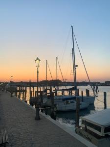 a group of boats docked at a dock at sunset at Casa Azzurra in Chioggia