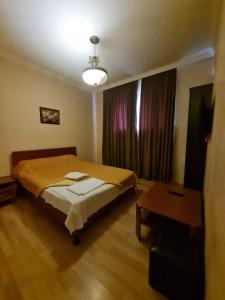 Un dormitorio con una cama y una mesa. en Piano Hotel en Tiflis