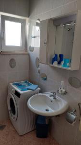 a bathroom with a sink and a washing machine at Apartments Eti in Bol +71 photos