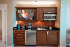 a kitchen with a sink and a tv on the wall at NO RESORT FEES-MGM Stripview-Jacuzzi-Formula 1 TRACK VIEW in Las Vegas