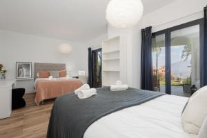1 dormitorio con 2 camas y ventana grande en Spectacular villa, with infinity pool and sea views, la Mairena, Elviria, Marbella en Ojén