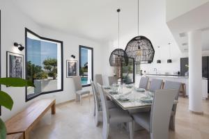 comedor y cocina con mesa y sillas en Spectacular villa, with infinity pool and sea views, la Mairena, Elviria, Marbella, en Ojén