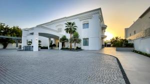 a large white building with a driveway at Villa Botanica-Exclusive 8-Bedroom Villa by Luxury Explorers' Collection in Dubai