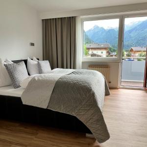 a bedroom with a bed and a large window at Appartements by Hofer in Kaprun