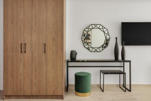 Cens Bronze Luxury Suites في يوانينا: غرفة بها مكتب ومرآة ومقعد