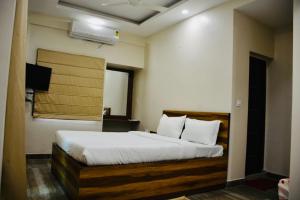 a bedroom with a large bed with white sheets at Hotel Royal Residency in Kolkata