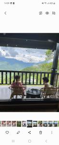 dwie osoby siedzące przy stole na balkonie z widokiem w obiekcie Heaven house w mieście Sa Pa