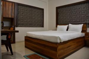 a bedroom with a large bed with a desk and a desk at Hotel Royal Residency in Kolkata