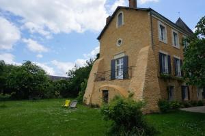 un gran edificio de ladrillo en medio de un campo en Le Prieuré en Lézigné